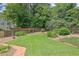 Green backyard featuring a wood fence and lush landscaping at 5950 Meadow Brook Ln, Cumming, GA 30040