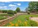 Manicured backyard with stone retaining wall, garden beds and a well maintained lawn at 5950 Meadow Brook Ln, Cumming, GA 30040