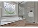 This bathroom features a soaking tub, decorative window and glass shower at 5950 Meadow Brook Ln, Cumming, GA 30040