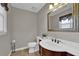 Charming powder room featuring a decorative mirror, vanity, and tiled flooring at 5950 Meadow Brook Ln, Cumming, GA 30040