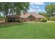 Sprawling brick home with an expansive lawn and mature trees offering a tranquil setting at 5950 Meadow Brook Ln, Cumming, GA 30040