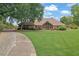 Traditional brick home with manicured lawn and driveway at 5950 Meadow Brook Ln, Cumming, GA 30040