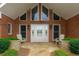 Inviting front porch with stone accents, chairs and a brick exterior providing curb appeal at 5950 Meadow Brook Ln, Cumming, GA 30040