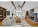 Bright living room featuring vaulted ceilings, exposed beams, a fireplace, and built-in shelving at 5950 Meadow Brook Ln, Cumming, GA 30040