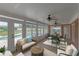 Cozy sunroom featuring a seating area, dining space, stone floors, and a view of the pool at 5950 Meadow Brook Ln, Cumming, GA 30040