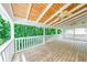 Covered outdoor porch with view of backyard greenery and a white railing at 1265 Kelly Nelson Dr, Lawrenceville, GA 30043