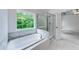 Bathroom featuring soaking tub, tiled shower, and scenic window view at 1265 Kelly Nelson Dr, Lawrenceville, GA 30043