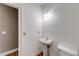 Half bath with pedestal sink, white fixtures, and hardwood-style floors at 1265 Kelly Nelson Dr, Lawrenceville, GA 30043