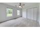 Bright bedroom features two windows, a ceiling fan, carpet flooring, and closet with bi-fold doors at 1265 Kelly Nelson Dr, Lawrenceville, GA 30043