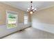 Light-filled dining room with carpet, wainscoting, chandelier, and bright windows overlooking the front yard at 1265 Kelly Nelson Dr, Lawrenceville, GA 30043
