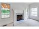 Modern fireplace with white mantle and marble hearth near a large window overlooking a green space at 1265 Kelly Nelson Dr, Lawrenceville, GA 30043