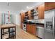 Kitchen features stainless appliances, light wood cabinets, and view to a living area at 1271 Ponti Nw Mews # 92, Atlanta, GA 30318