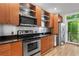Kitchen with stainless steel appliances, wood cabinets, and a view of the outside at 1271 Ponti Nw Mews # 92, Atlanta, GA 30318