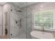 Elegant bathroom with a glass-enclosed shower, soaking tub, and marble tile at 1605 Little Lisa Ln, Snellville, GA 30078