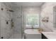 Elegant bathroom with a glass-enclosed shower, soaking tub, and marble tile and double vanity at 1605 Little Lisa Ln, Snellville, GA 30078