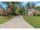 Long driveway leads to a charming stucco home with lush landscaping, located in a desirable neighborhood at 1605 Little Lisa Ln, Snellville, GA 30078