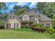 Charming stucco home with manicured lawn and colorful shrubs and decorative plants in a quiet suburban neighborhood at 1605 Little Lisa Ln, Snellville, GA 30078
