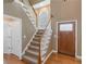 Bright foyer featuring hardwood floors, staircase with white railings, and a decorative front door with glass details at 1605 Little Lisa Ln, Snellville, GA 30078