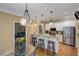 Open-concept kitchen with bar seating, stainless steel appliances, and hardwood floors at 1605 Little Lisa Ln, Snellville, GA 30078