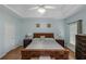 Serene main bedroom with light blue walls, hardwood floors, tray ceiling and furnishings at 1605 Little Lisa Ln, Snellville, GA 30078