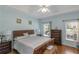 Serene main bedroom with light blue walls, hardwood floors, tray ceiling, two windows with views of the yard at 1605 Little Lisa Ln, Snellville, GA 30078