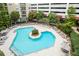 Aerial view of sparkling pool with surrounding lounge chairs, tables, cabana, and lush landscaping at 390 17Th Nw St # 4055, Atlanta, GA 30363