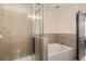 Well-lit bathroom featuring a shower with glass door, a soaking tub, tiled walls, and modern fixtures at 390 17Th Nw St # 4055, Atlanta, GA 30363