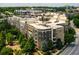 View of condo building and grounds, featuring mature landscaping, walkways, and a paved street at 390 17Th Nw St # 4055, Atlanta, GA 30363