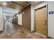 Long condo hallway with tile floor, brown accent wall, and decorative glass block window at 390 17Th Nw St # 4055, Atlanta, GA 30363