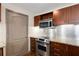 Kitchen features stainless steel oven, flat cooktop, granite countertop, and dark wood cabinets at 390 17Th Nw St # 4055, Atlanta, GA 30363