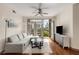 Inviting living room with hardwood floors, a ceiling fan, and a balcony showcasing city views at 390 17Th Nw St # 4055, Atlanta, GA 30363