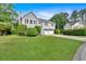 Split-level home on a well manicured lawn with trees and shrubbery, two-car garage, and a long driveway at 4807 Willowwood Ne Dr, Kennesaw, GA 30144