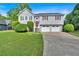 Charming split-level home featuring a two-car garage, gray siding, mature trees, and a well-manicured front yard at 4807 Willowwood Ne Dr, Kennesaw, GA 30144