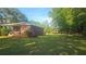 Lush backyard showcasing a covered patio and mature trees at 112 Hilltop Dr, Newborn, GA 30056
