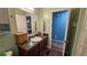 Well-lit bathroom with a wooden vanity, a sink, and an adjacent shower with stylish blue walls at 112 Hilltop Dr, Newborn, GA 30056