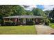 Charming brick home with a well-maintained lawn, carport, and an American flag displayed out front at 112 Hilltop Dr, Newborn, GA 30056