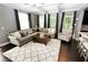 Open-concept living room with a plush sectional sofa, hardwood floors, and large windows at 116 Festoon Ct, Smyrna, GA 30080