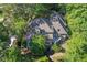 Aerial view of a home with a circular driveway nestled among trees, and expansive back yard at 181 Sentinel Pl, Marietta, GA 30067