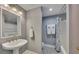 Cozy bathroom features a pedestal sink, well-lit mirror, and shower/tub combo with tile floors at 181 Sentinel Pl, Marietta, GA 30067