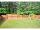 Wooden playground set stands ready for fun in a big backyard with a privacy fence at 2210 Valley Creek Dr, Lithia Springs, GA 30122