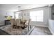 Bright dining room boasts stylish rug, dining set, modern light fixture, and neutral walls at 2210 Valley Creek Dr, Lithia Springs, GA 30122