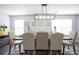 Bright dining room boasts stylish rug, dining set, modern light fixture, and neutral walls at 2210 Valley Creek Dr, Lithia Springs, GA 30122