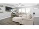 Spacious living room features gray plank flooring, a ceiling fan, and large sectional sofa at 2210 Valley Creek Dr, Lithia Springs, GA 30122