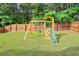 A wooden playground set with swings and a slide stands ready for fun in this backyard at 2210 Valley Creek Dr, Lithia Springs, GA 30122