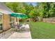 Green backyard features a patio, table and chairs, a green umbrella, and plenty of room for activities at 5850 Shannon Dr, Cumming, GA 30040