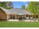 Brick house shows off an amazing backyard including a patio, outdoor seating, and well-maintained lawn at 5850 Shannon Dr, Cumming, GA 30040