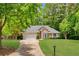 Charming brick home featuring a manicured lawn, two-car garage and a beautifully landscaped front yard at 5850 Shannon Dr, Cumming, GA 30040