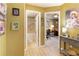 Hallway view of neutral paint, decorative pictures, bathroom and possible office access at 5850 Shannon Dr, Cumming, GA 30040