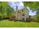 View of the back of the house with a spacious lawn, deck, and surrounding trees at 84 Conner Glenn Dr, Hiram, GA 30141