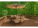 Outdoor deck with dining set under an umbrella and surrounded by lush greenery at 84 Conner Glenn Dr, Hiram, GA 30141